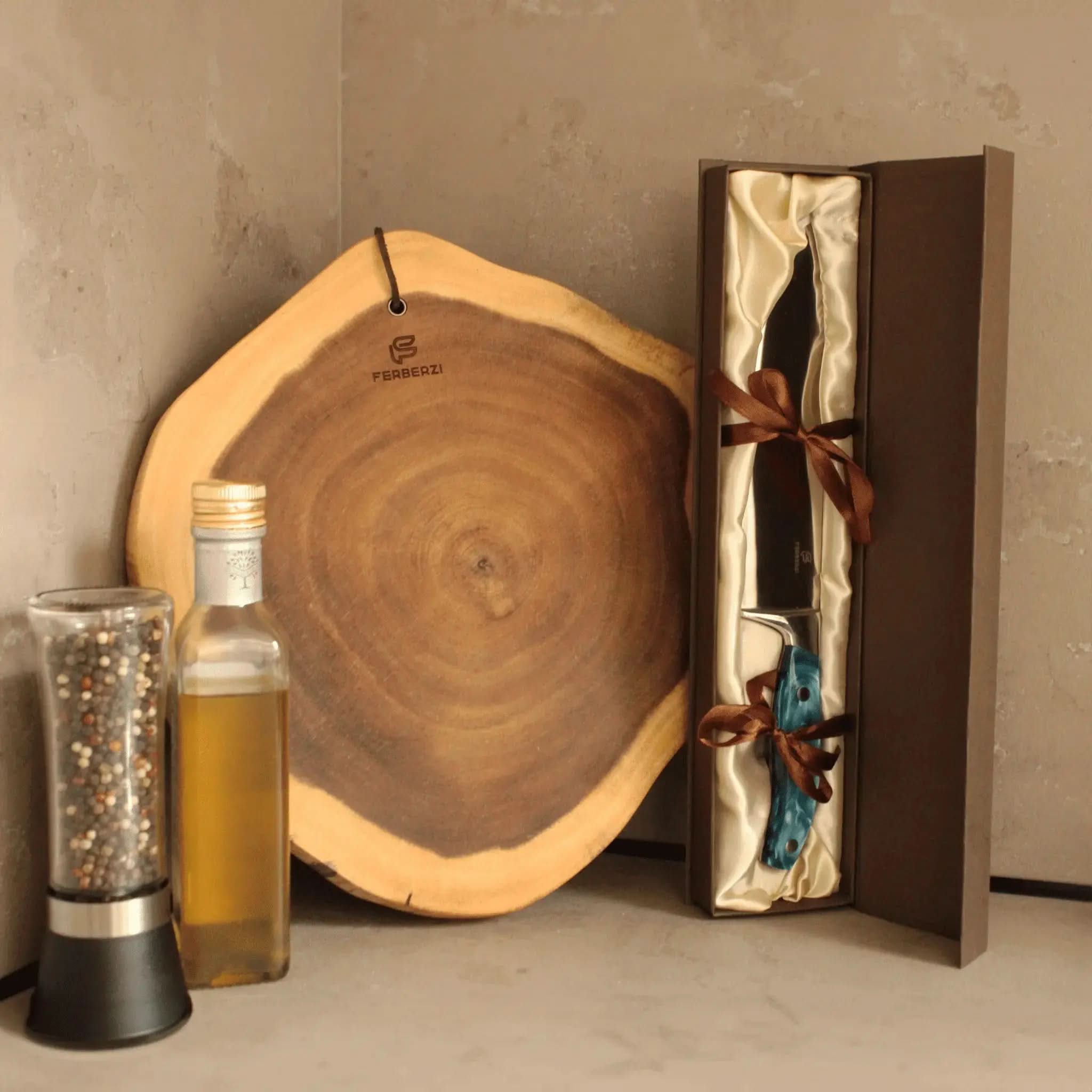Koksmes met blauw acryl handvat in luxe geschenkdoos naast acaciahouten snijplank