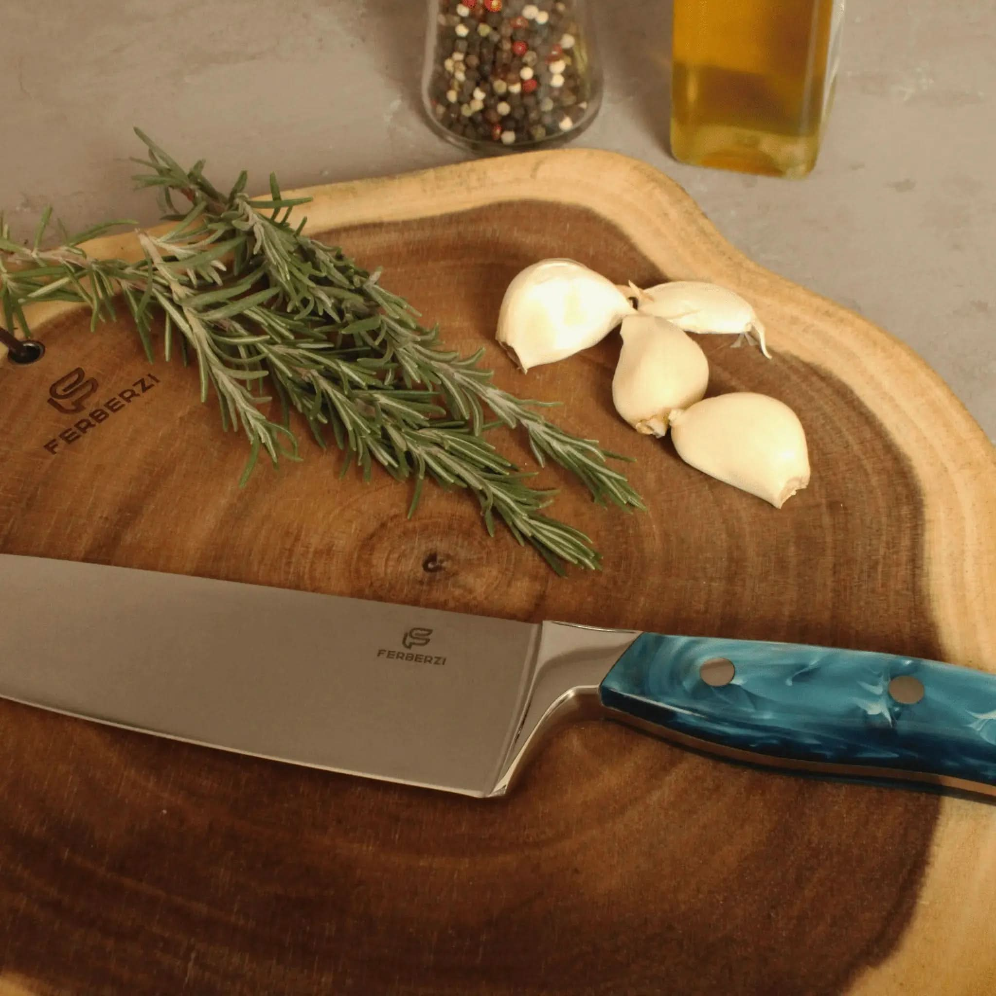 Koksmes met blauw acryl handvat op acaciahouten snijplank met knoflook en rozemarijn