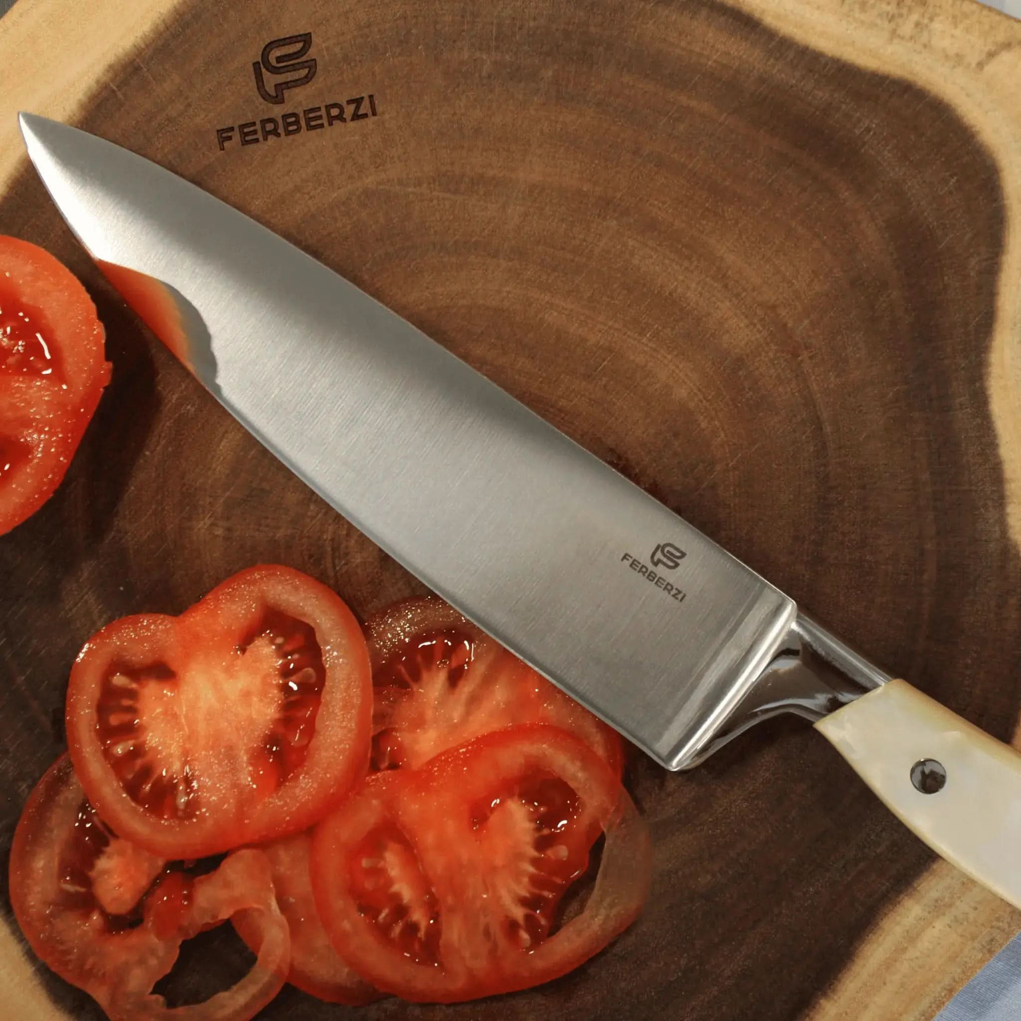 Koksmes met parelwit acryl handvat op acaciahouten snijplank met gesneden tomaten